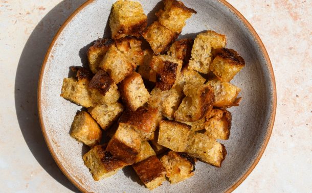 Focaccia Croutons in a stone bowl in direct sunlight.