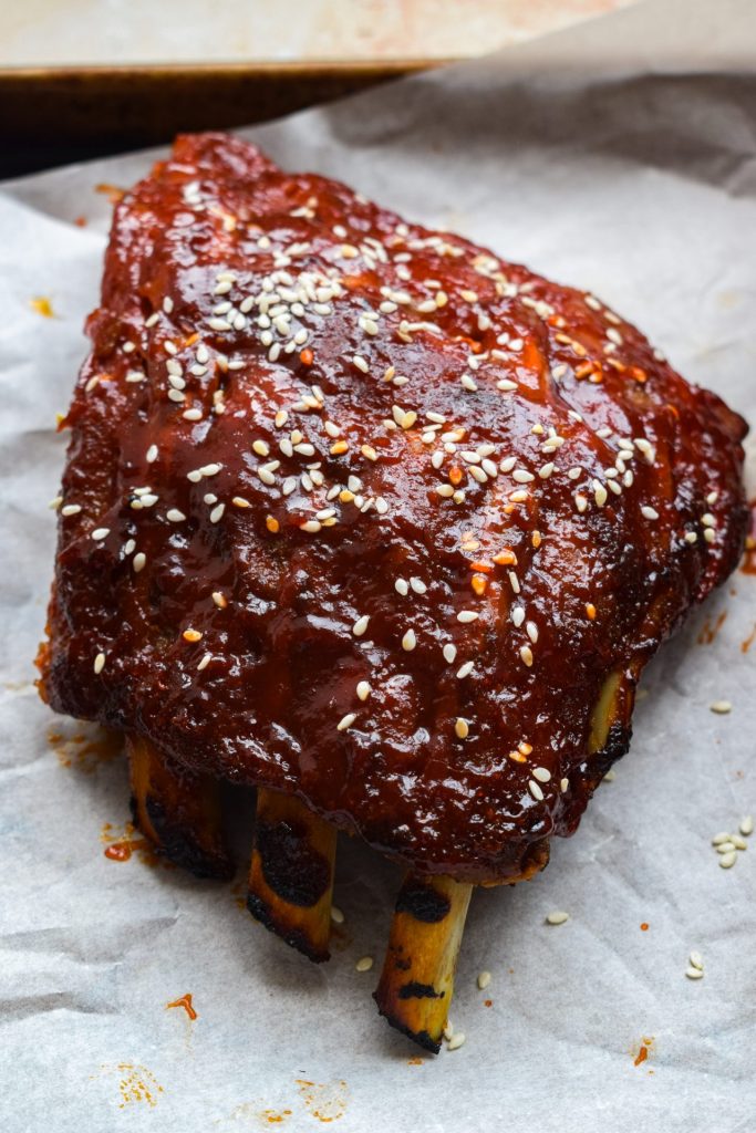 Close up of half a rack of gochujang baby back ribs sprinkled with sesame seeds.