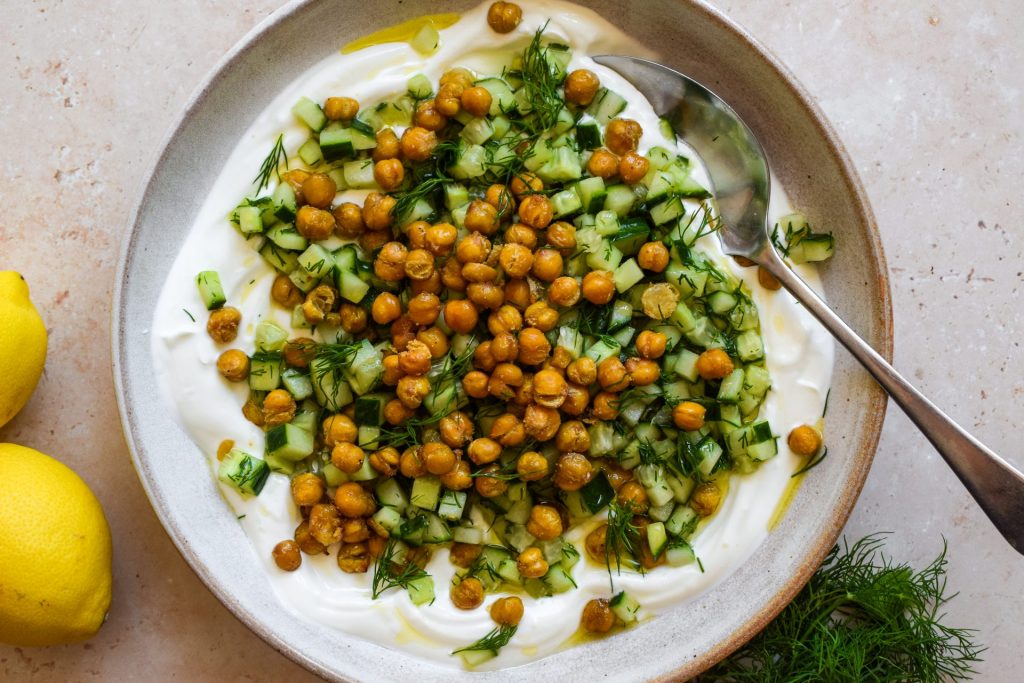 Crispy chickpeas and a dill and cucumber salad piled onto a bowl of thick Greek-style yogurt.
