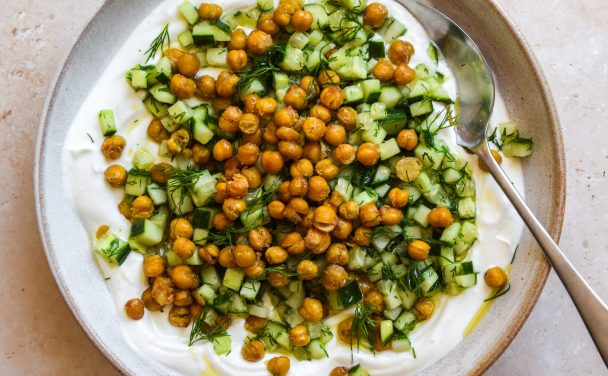 Bowl of crispy chickpeas and chopped cucumber on top of thick yogurt.