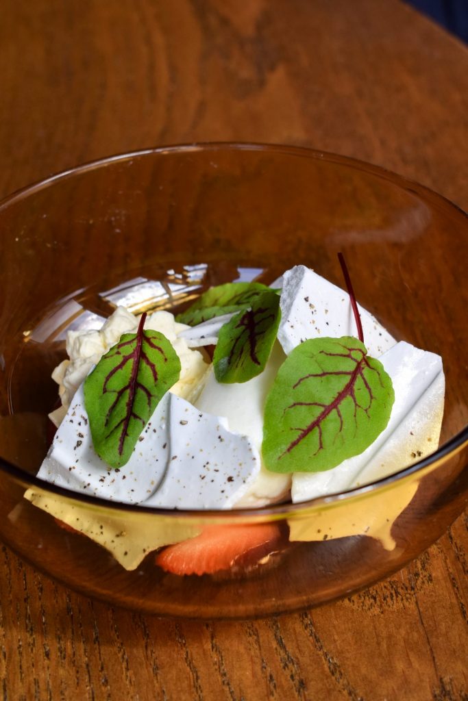 Orange of glass bowl filled with Eton mess on a pub table.