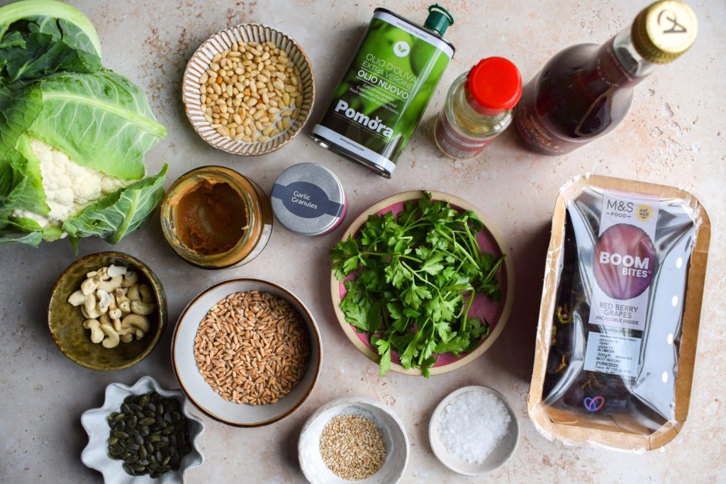 Laid out ingredients to make a cauliflower and grape spelt salad.